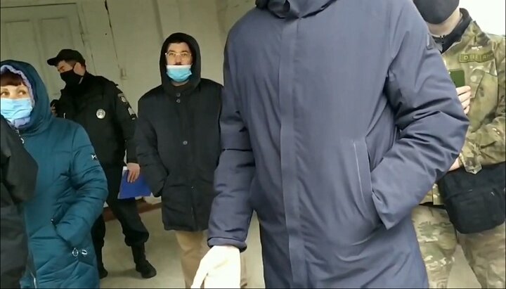 Неизвестные в масках в присутствии полиции не дают прихожанам УПЦ попасть в храм на богослужение в Припутнях. Фото: скриншот видео yuotube-канала Нежинской епархии.