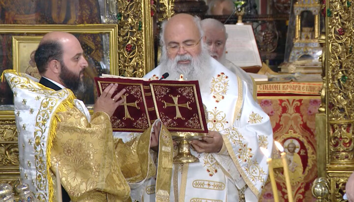 Архиепископ Георгий читает диптих. За ним стоит митрополит Никифор Киккский. Фото: скриншот YouTube-канала  Ι. Μ. Κύκκου