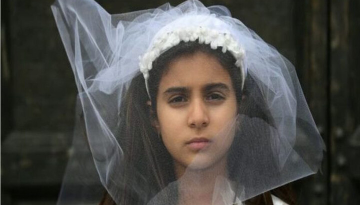 A young actress portrays a child bride during an Amnesty International protest against child marriage. Photo: rferl.org