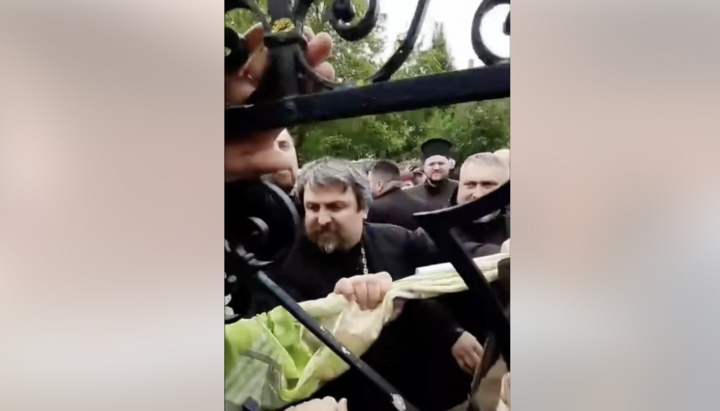 OCU cleric breaking the gate of the UOC church in Zastavna. Photo: UOJ