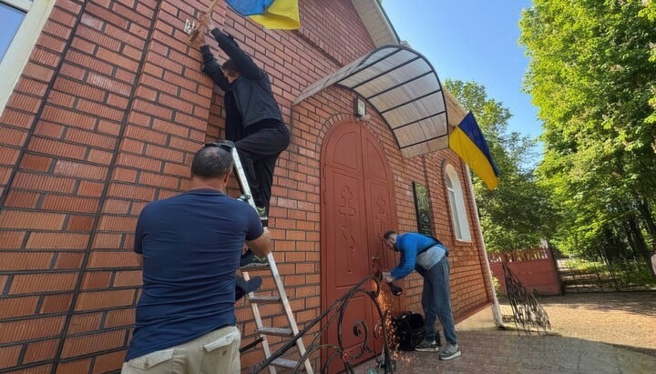 Активісти зрізають замки на Пантелеймонівському храмі УПЦ. Фото: 1kr.ua